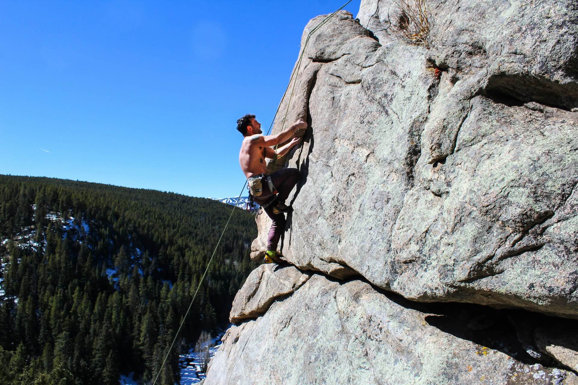 a man climbing a rock face for the climbing collective